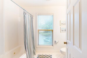 A bathroom with a shower, toilet, and a door with a doorknob. - Updated Island Escape with Dual Suites Golf, Tennis, Beach Club, Near Dining (Hilton Head)