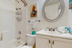 A bathroom with a bathtub, toilet, sink, and a large mirror. - Beach condo with Ocean Views, outdoor pool & balcony - Walk to Beach (Hilton Head)