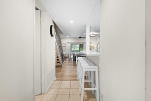 A hallway with a staircase leading to a room with a view of greenery. - Harbour Town Stoney Creek Townhouse Balconies, Pool, Golf and Tennis! (Hilton Head)