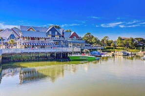 A waterfront hotel with a dock, boats, and a bridge. - Harbour Town Stoney Creek Townhouse Balconies, Pool, Golf and Tennis! (Hilton Head)