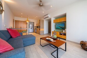 Ein modernes Wohnzimmer mit einer Couch, einem Couchtisch und einem Fernseher.
