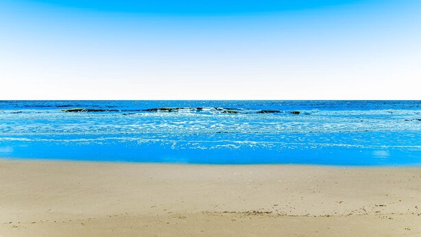A beach with clear blue water and a sandy shore. - Coastal Condo with Pool, Hot Tub, Tennis, Fast WiFi, AC, & WD, Near the Beach (Hilton Head)