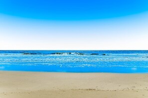 A beach with clear blue water and a sandy shore. - Coastal Condo with Pool, Hot Tub, Tennis, Fast WiFi, AC, & WD, Near the Beach (Hilton Head)