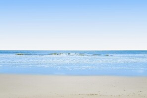 A beach with clear skies and calm waves. - Your relaxing beach getaway — steps from a refreshing pool, minutes from the sand, and onsite tennis/pickleball courts (Hilton Head)