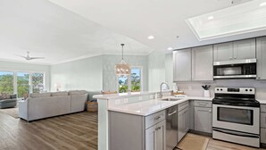 A modern kitchen with grey cabinets, a built-in oven, and a large island. - Coastal condo on the beach with panoramic views, beach access & a shared pool (Hilton Head)