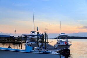 A marina with boats docked, a pier, and a bridge in the background. - Coastal Condo with Shared Pool  Steps to the Beach, Walking Distance to Shopping and Dining (Hilton Head)