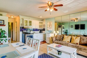 Un espacio habitable compacto con kitchenette, comedor y sofá.