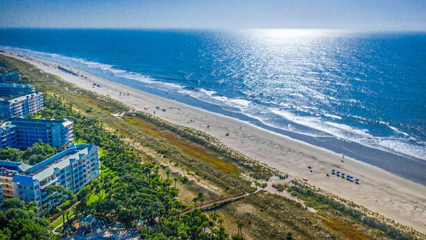 Een kusthotel met meerdere gebouwen, een strand en uitzicht op de oceaan.