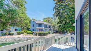 A wooden deck with a view of a house and a body of water. - Dog-friendly island escape near the beach with pool, water view & WiFi (Hilton Head)