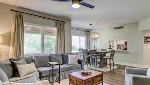 Un salon comprenant un canapé, une table basse et un coin repas avec des chaises et une table.