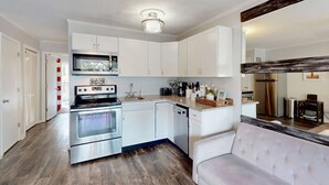 Una cocina moderna con armarios blancos, electrodomésticos de acero inoxidable y un microondas integrado.