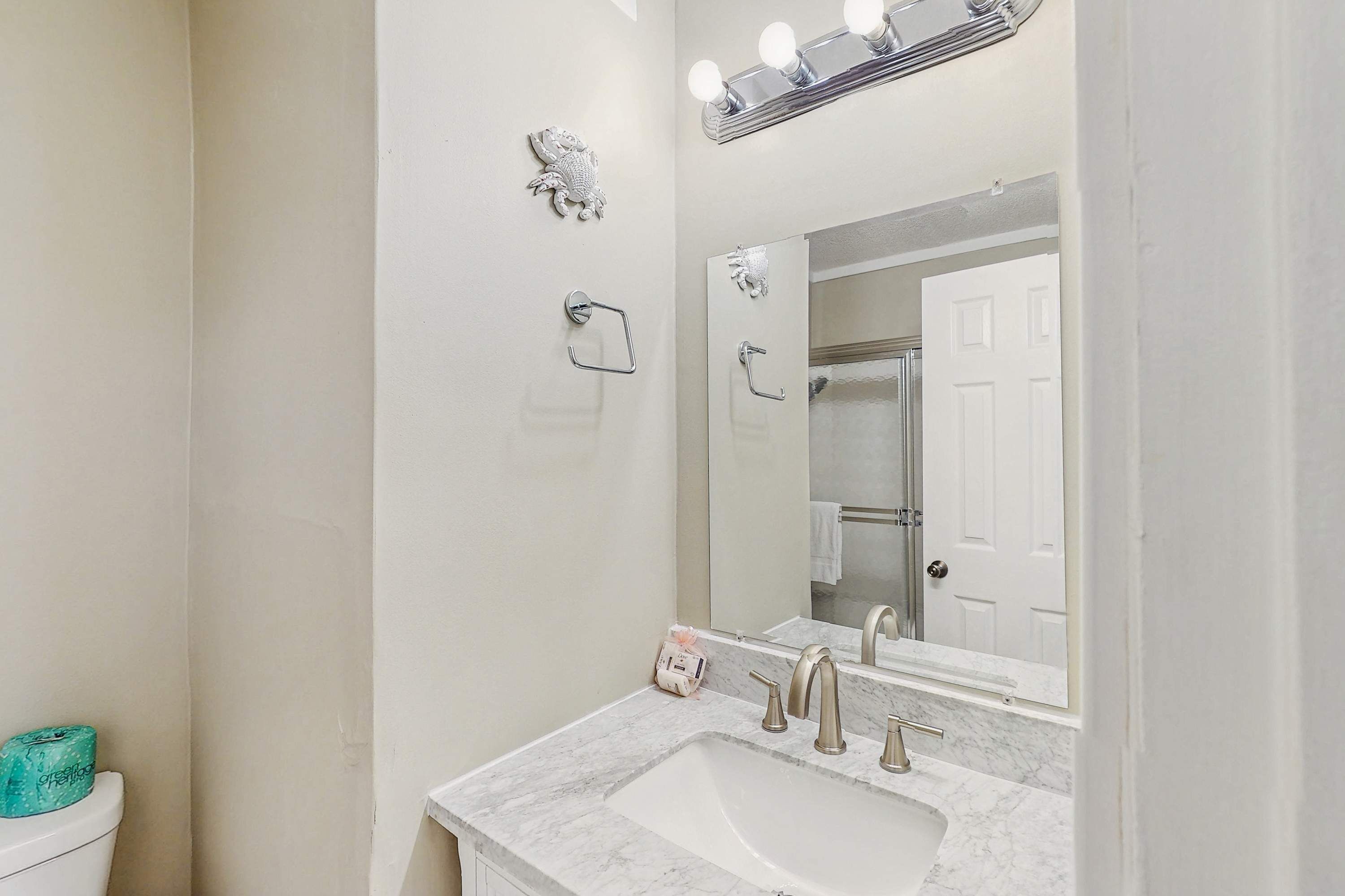 A bathroom with a sink, mirror, and towel rack.