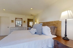 A bedroom with a bed, a dresser, a lamp, and a mirror. - Sea Pines Home on 18th Hole of Atlantic Dunes with Private Pool & New Deck 2 DogsOK (Hilton Head)