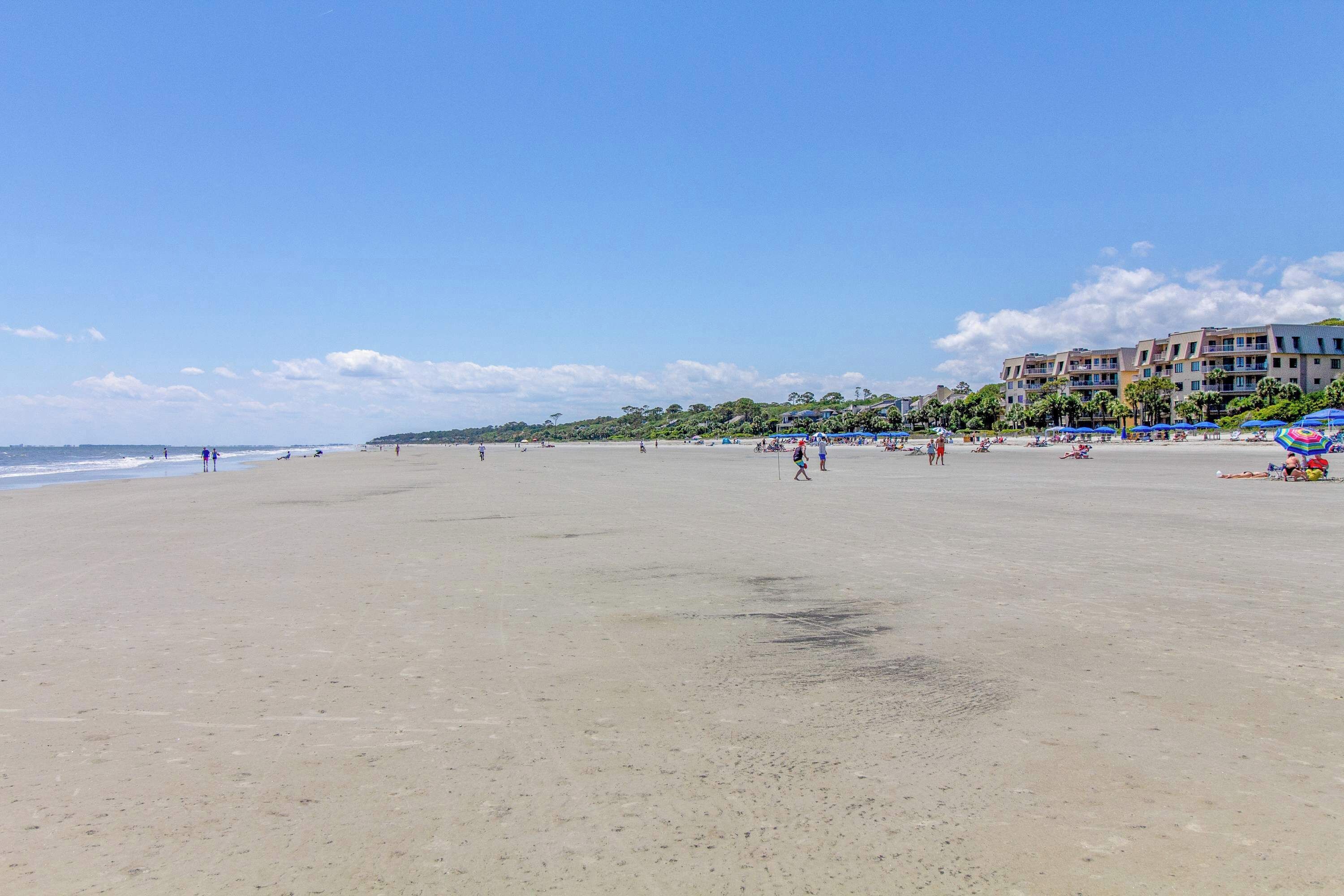 Una playa con un edificio al fondo.