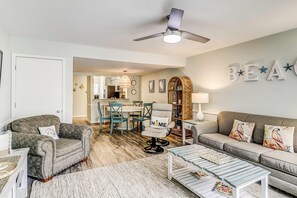 A living room with a sofa, armchair, coffee table, and a ceiling fan. - Courtside Villas Retreat with pools & tennis courts near beach & Coligny fun (Hilton Head)