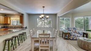 A spacious kitchen with a dining area, large windows, and a chandelier. - Cozy dog-friendly home with free WiFi & private pool for a relaxing stay (Hilton Head)