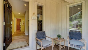 A porch with two chairs and a small table, wooden flooring, and a door leading to an interior hallway. - Cozy dog-friendly home with free WiFi & private pool for a relaxing stay (Hilton Head)