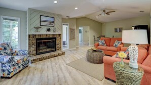 A living room with a fireplace, a sofa, a coffee table, and a lamp. - Cozy dog-friendly home with free WiFi & private pool for a relaxing stay (Hilton Head)