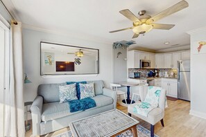 A living room with a sofa, coffee table, and a ceiling fan. - Top Floor Condo w/ Ocean Views, Pool, Balcony & WIFI - Walk to Beach (Hilton Head)