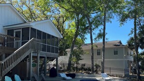 A residential property with a swimming pool, outdoor seating, and a covered deck area. - Gas Money (Edisto Beach)