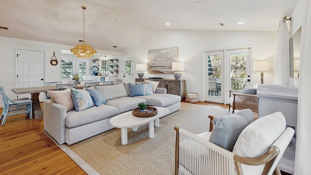 A spacious living area with a sofa, coffee table, and a dining table. - Gas Money (Edisto Beach)