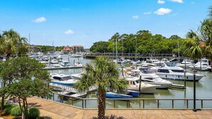 Un port de plaisance où sont amarrés des bateaux, entouré d’arbres et sous un ciel dégagé.