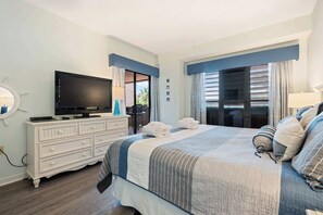 A hotel room with a bed, a TV, a dresser, and a window with curtains. - Waterfront condo with walkable locale, central AC, washer dryer, & shared pool (Hilton Head)