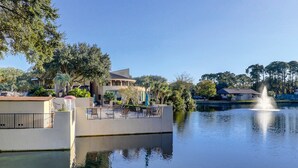 A waterfront property with a pool, a fountain, and a building with a balcony. - Beachfront escape with pools, hot tub, WiFi, washer/dryer, & central AC (Hilton Head)