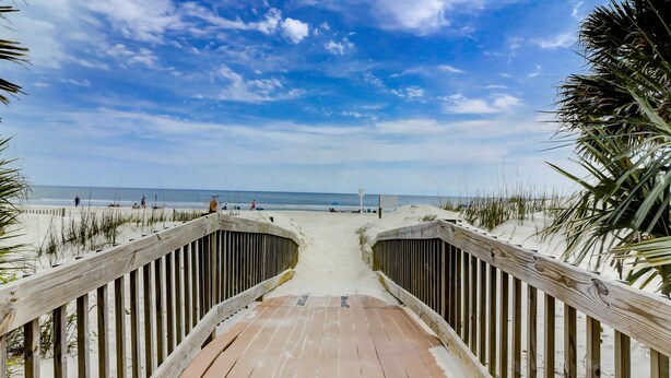 A wooden boardwalk leading to a beach with a clear sky. - Charming condo with shared pools and hot tub, high-speed WiFi, and central AC (Hilton Head)
