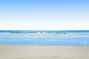 A beach with clear water and a sandy shore. - 3rd floor condo with private balcony, AC, Washer and Dryer, on site pools, hot tub & tennis (Hilton Head)