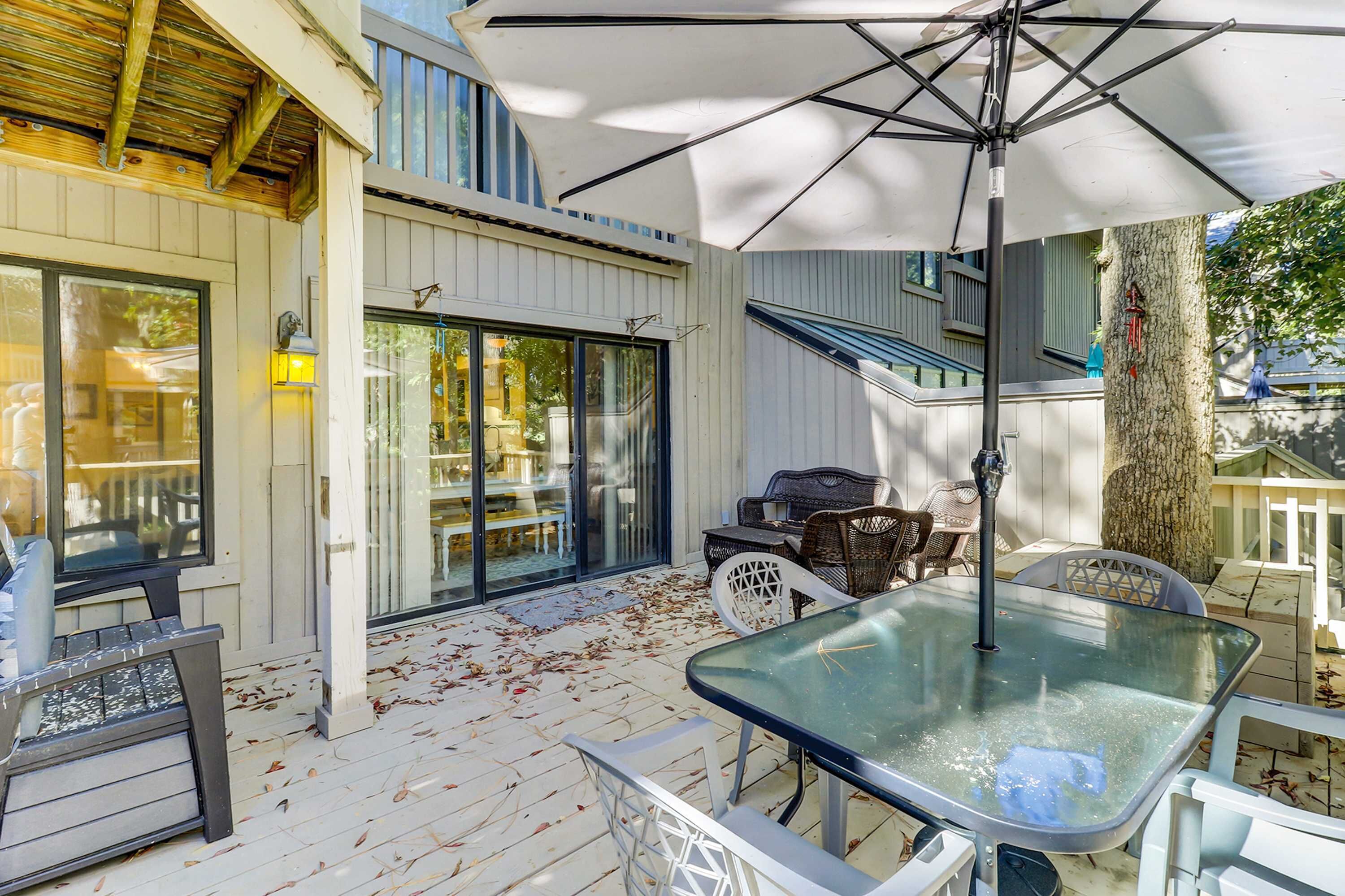 A covered patio with a table, chairs, and an umbrella.