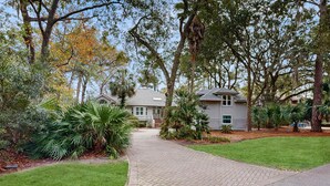 A residential area with a paved walkway, houses, and various trees. - Beautiful half acre estate home with private hot tub and passes to the shared pool (Hilton Head)