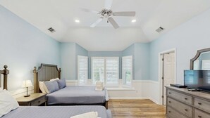 A bedroom with two beds, a ceiling fan, a dresser, a TV, and a window with blinds. - Beautiful half acre estate home with private hot tub and passes to the shared pool (Hilton Head)