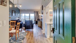 A hallway with a dining area, a sofa, and a green door. - Coastal charmer villa with cove front balcony & trolley  walk to beach (Hilton Head)