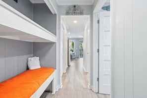 A narrow hallway with a bunk bed on the left, a white door on the right, and a sign above the door that reads 'SEASIDE'. - Stunning Newly Renovated Condo with Ocean View & Shared Pool Close to the Beach (Hilton Head)