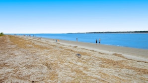 Una playa con arena dorada y un cielo azul despejado.