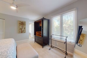 A bedroom with a bed, a dresser, a window with blinds, and a ceiling fan. - Secluded home & pool house with private pool - steps away from the beach (Hilton Head)
