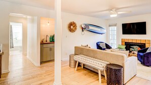 A living room with a sofa, a coffee table, a television, and a fireplace. - Relaxing Evian villa with patio, pool, tennis, pickleball, beach, golf, Dogs ok (Hilton Head)