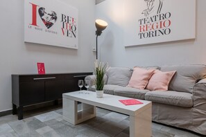 A modern living room with a sofa, a coffee table, and a cabinet. There are two framed posters on the wall. - Loft Regio by Wonderful Italy (Torino)