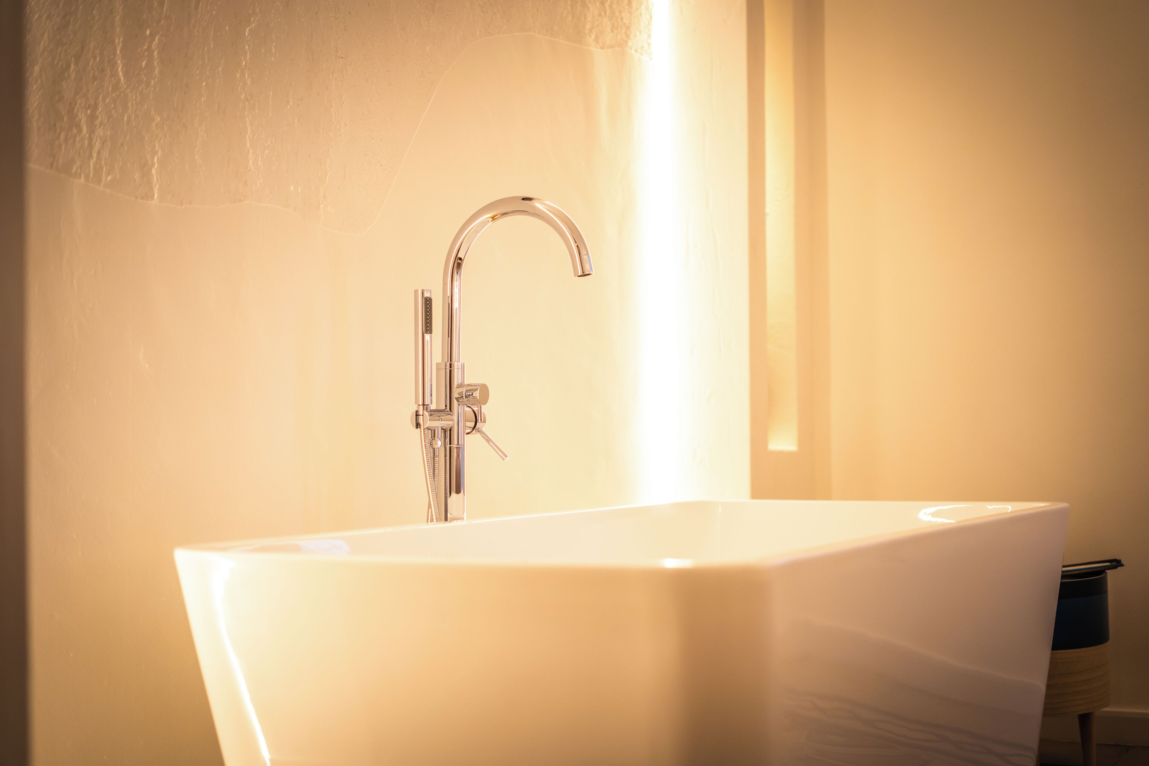 Un bagno con una vasca freestanding, un rubinetto moderno e un portascope.