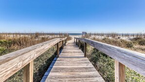 A wooden boardwalk leading to a beach with sand dunes and a clear blue sky. - Fully Renovated Sea Pines Home w Private Pool Six Rows from the Water  Dogs OK (Hilton Head)