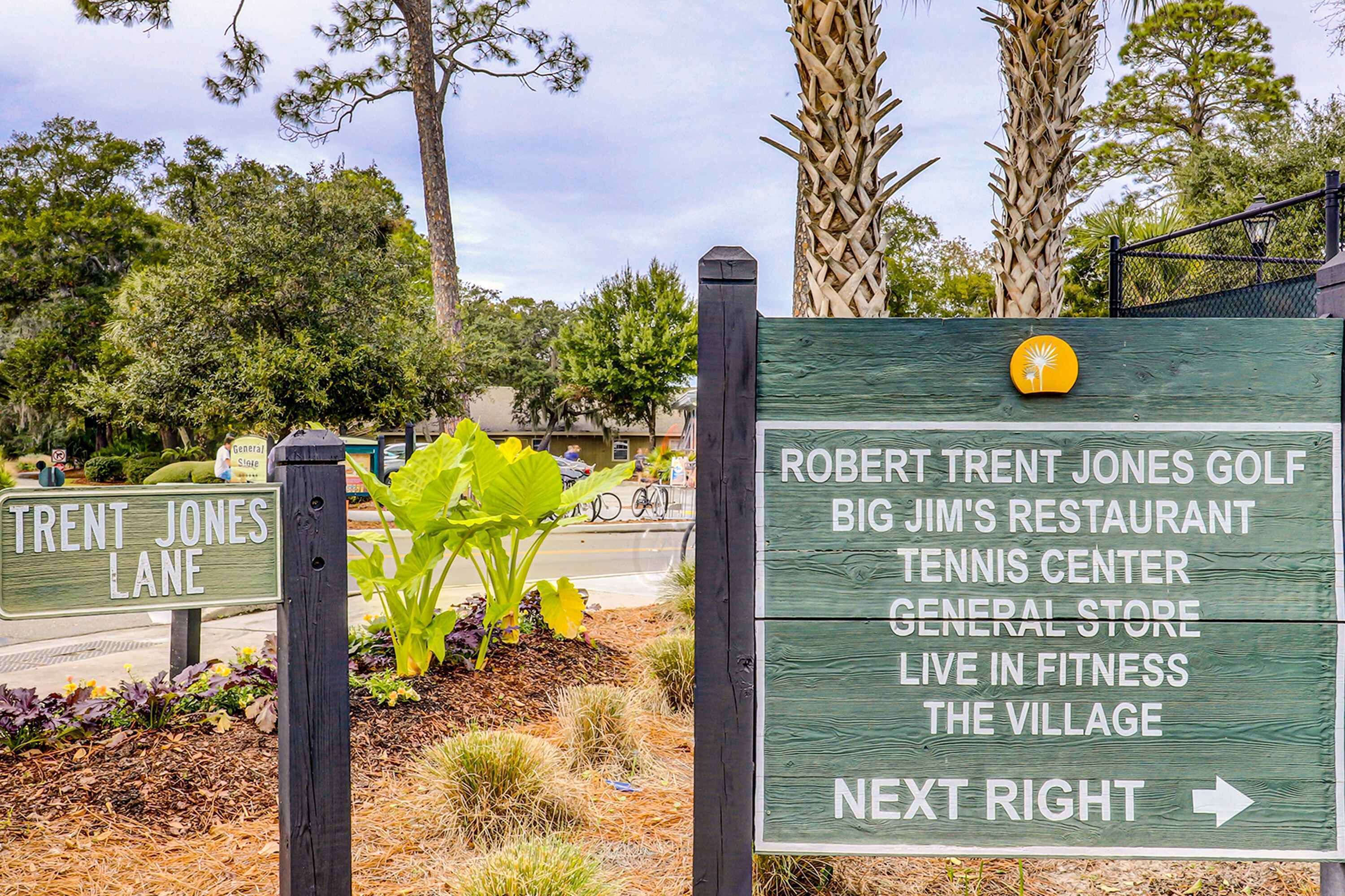 Een richtingsbord met tekst voor diverse lokale voorzieningen, waaronder een golfbaan, restaurant, tennishal en een algemene winkel.