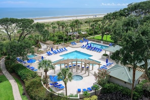 A resort with a central pool, sun loungers, and a view of the beach. - Bright & Airy Retreat with Balcony Views, Walkable Beach Access & Central Location (Hilton Head)