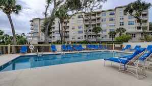 A swimming pool with blue lounge chairs, a lifeguard on duty sign, and a no diving allowed sign. - Bright & Airy Retreat with Balcony Views, Walkable Beach Access & Central Location (Hilton Head)