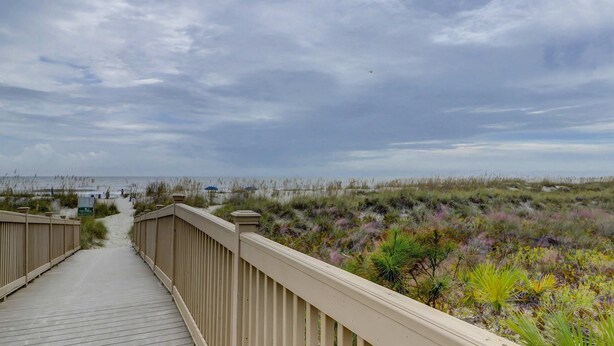 A wooden boardwalk leading to a beach with overcast skies. - Bright & Airy Retreat with Balcony Views, Walkable Beach Access & Central Location (Hilton Head)