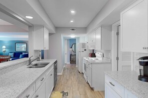 A modern kitchen with white cabinetry, a built-in oven, and a coffee maker. - Palmetto Dunes Condo with Golf Course Views, Pool & Tennis Access (Hilton Head)