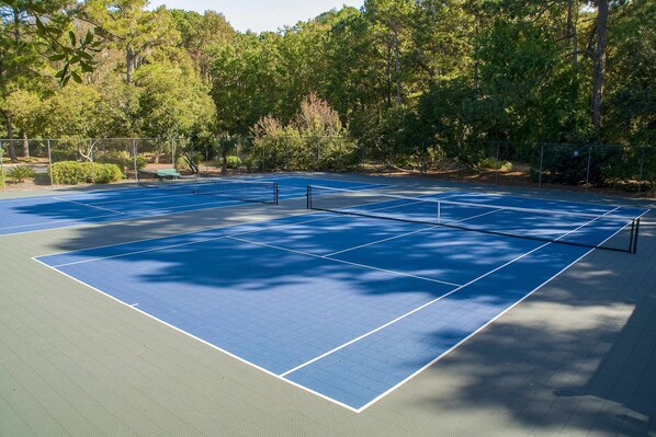 A tennis court surrounded by trees. - Retreat Condo with panoramic lagoon views, shared pool, golf courses & tennis courts (Hilton Head)