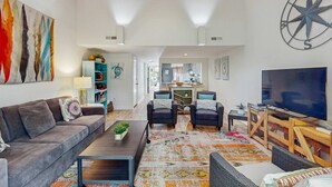 Un salón espacioso con sofá, sillones, una mesa de centro y televisor.