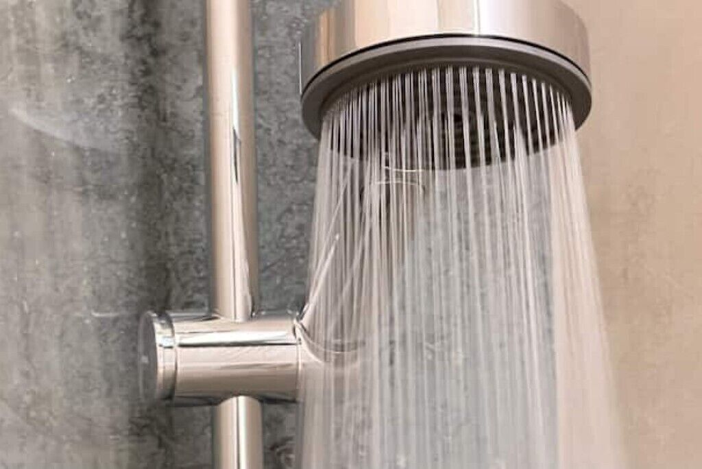 Un pommeau de douche d’où l’eau s’écoule.