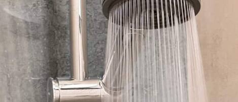 Un pommeau de douche d’où l’eau s’écoule.